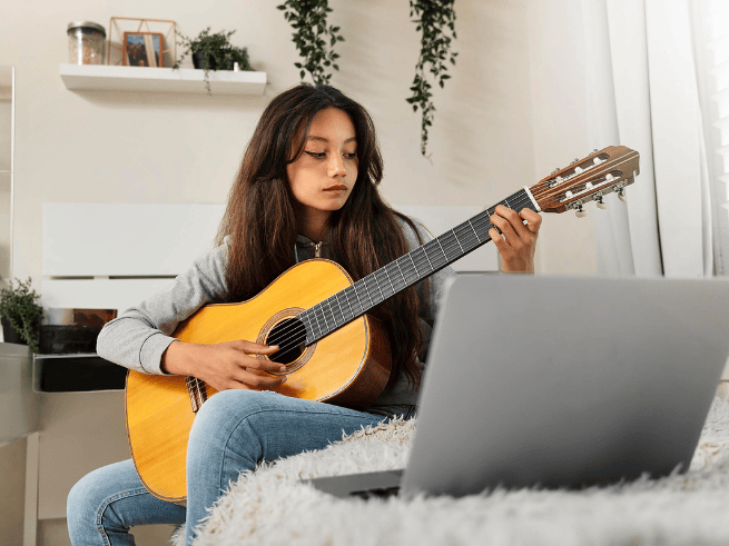 Teenage girl playing an acoustic guitar, perfect for online guitar classes for teenagers and online music lessons for teenagers