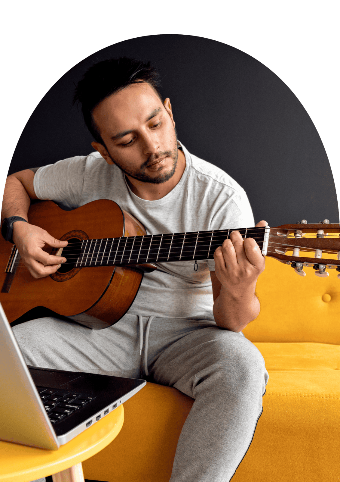 Person playing an acoustic guitar while in a cozy home setting, ideal for online music classes and online guitar lessons.